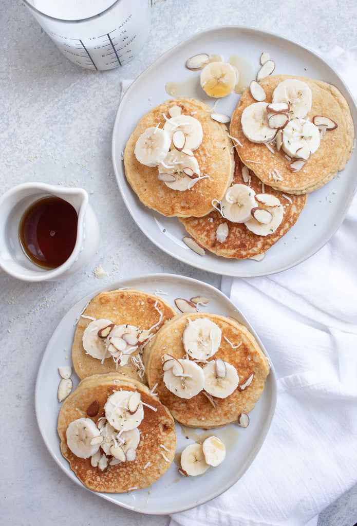 Gluten Free Banana Pancakes on plates with a side of maple syrup