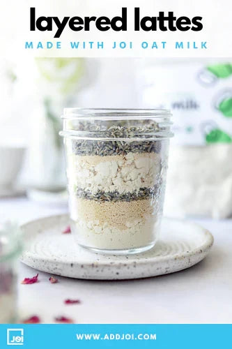 A glass jar of JOI layered latte mix, made with JOI oat milk, containing layers of lavender, rose, and honey.