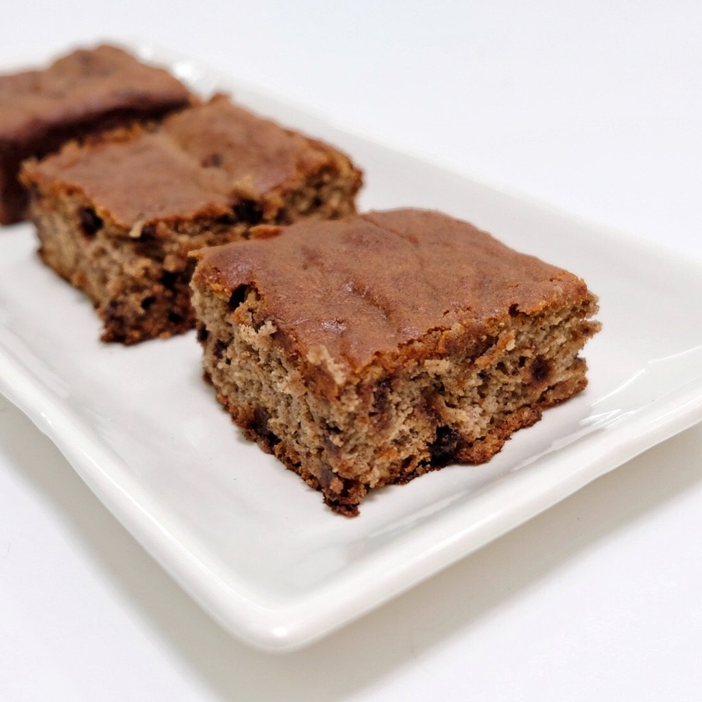Three square slices of Classic Banana Bread, made with JOI, on a white rectangular plate.