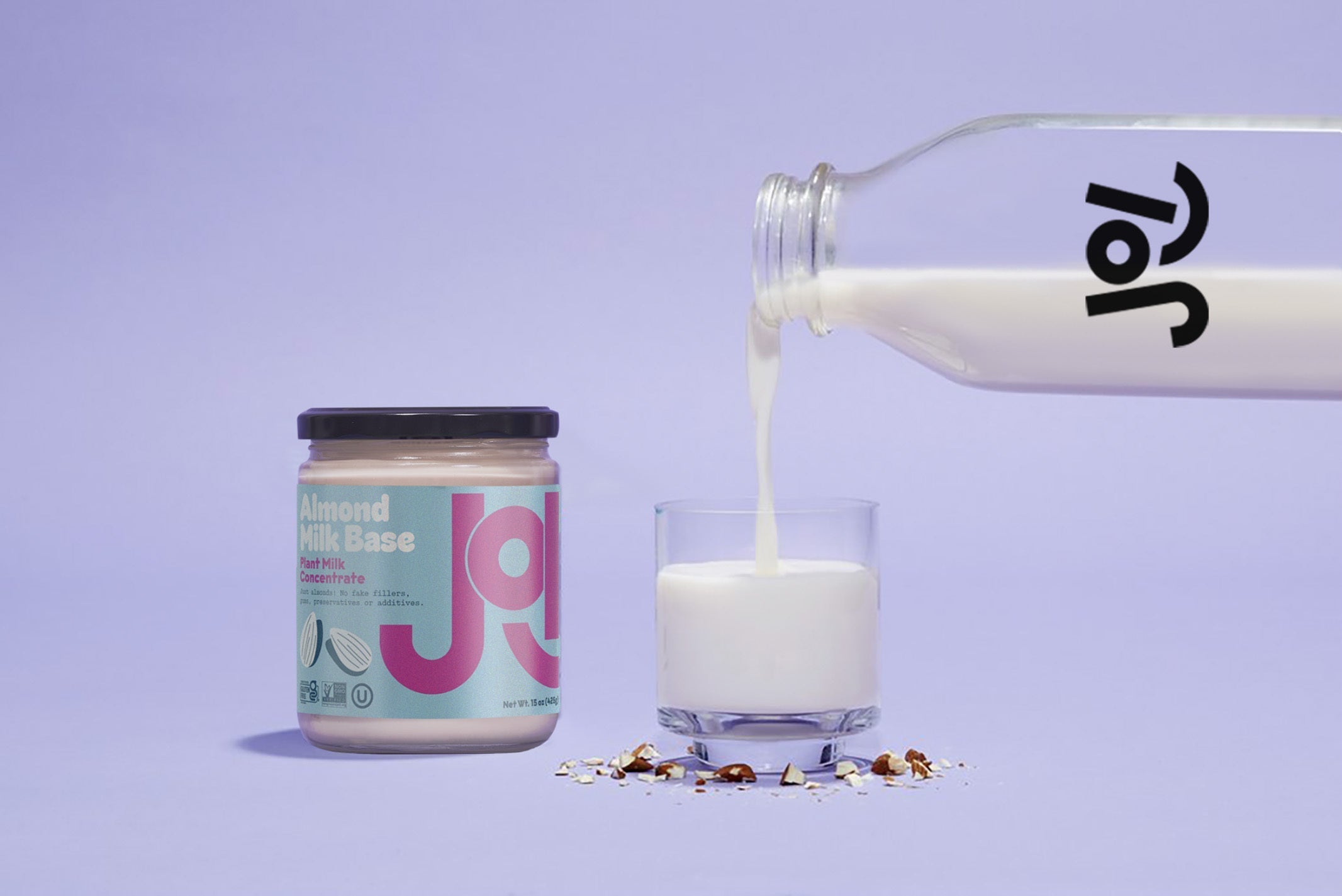 A jar of JOI almond milk base and a glass of milk with almonds at the base, with milk pouring from a bottle.