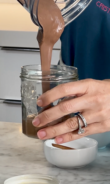 Chocolate flax chia pudding made with JOI plant base is poured from a blender into a glass jar.