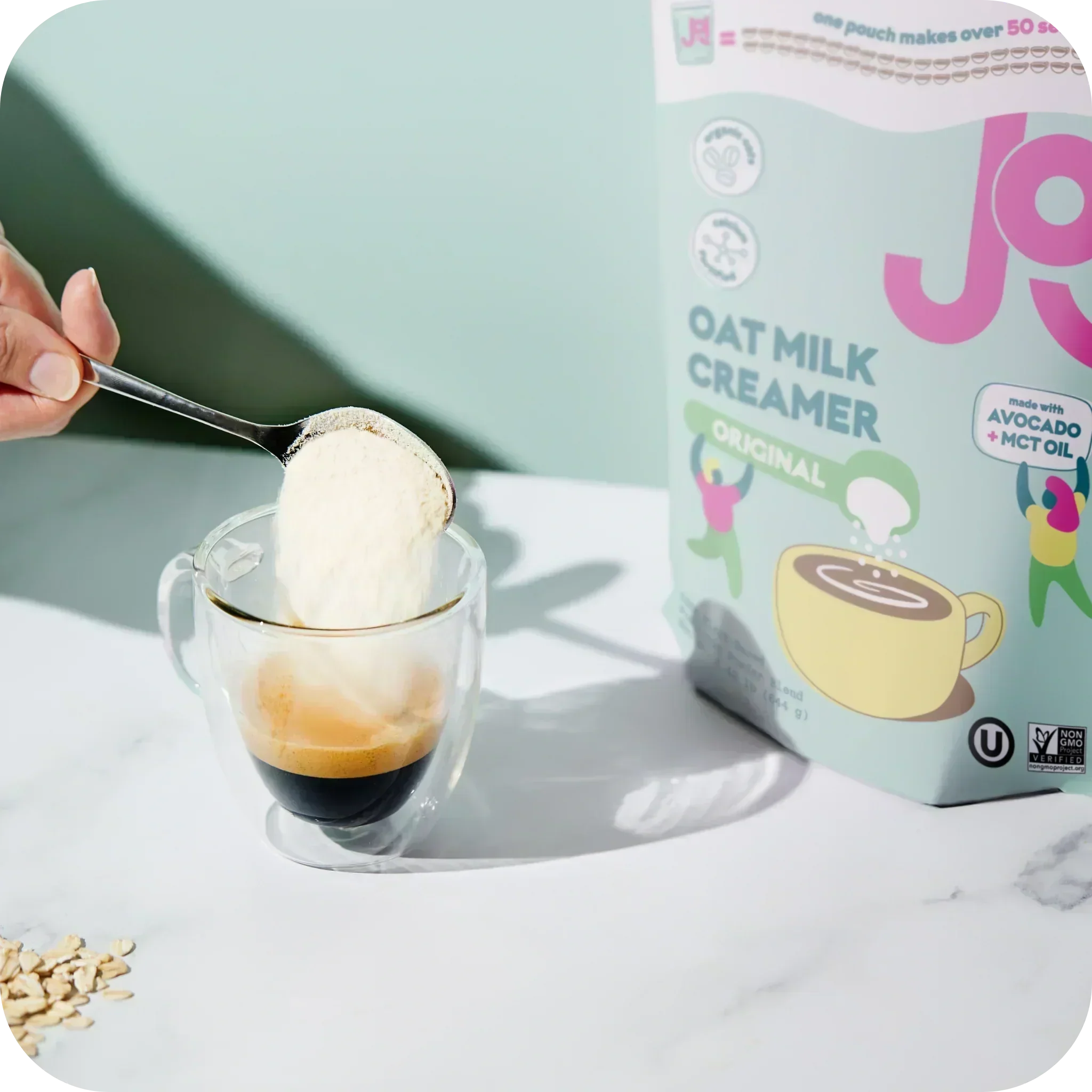 Spoonful of JOI Original Oat Milk Creamer ready to create a creamy black cold brew without masking the coffee.