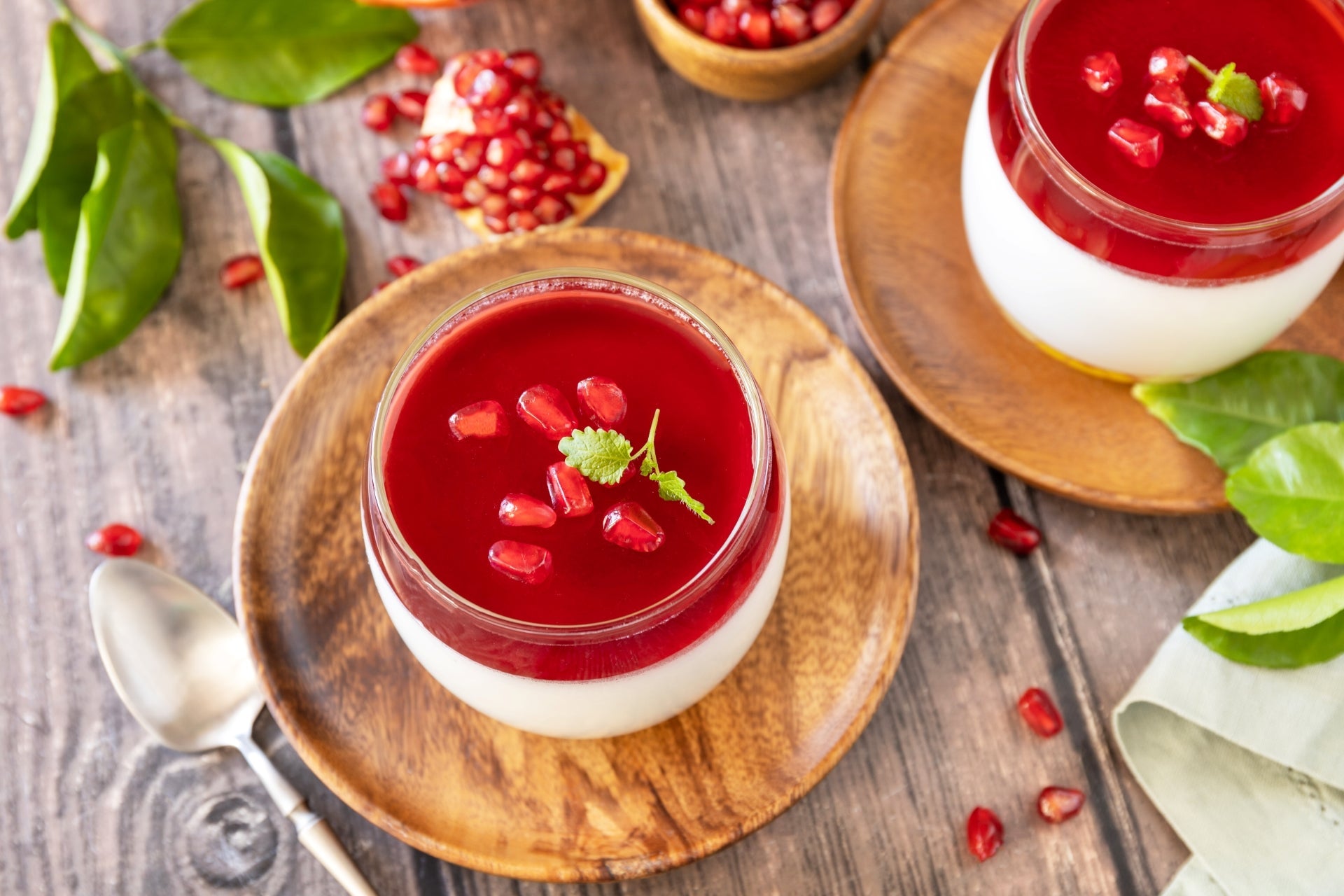 Vegan pomegranate-cashew panna cotta made at home using JOI cashew milk base and agar-agar and garnished with fresh pomegranate and basil.