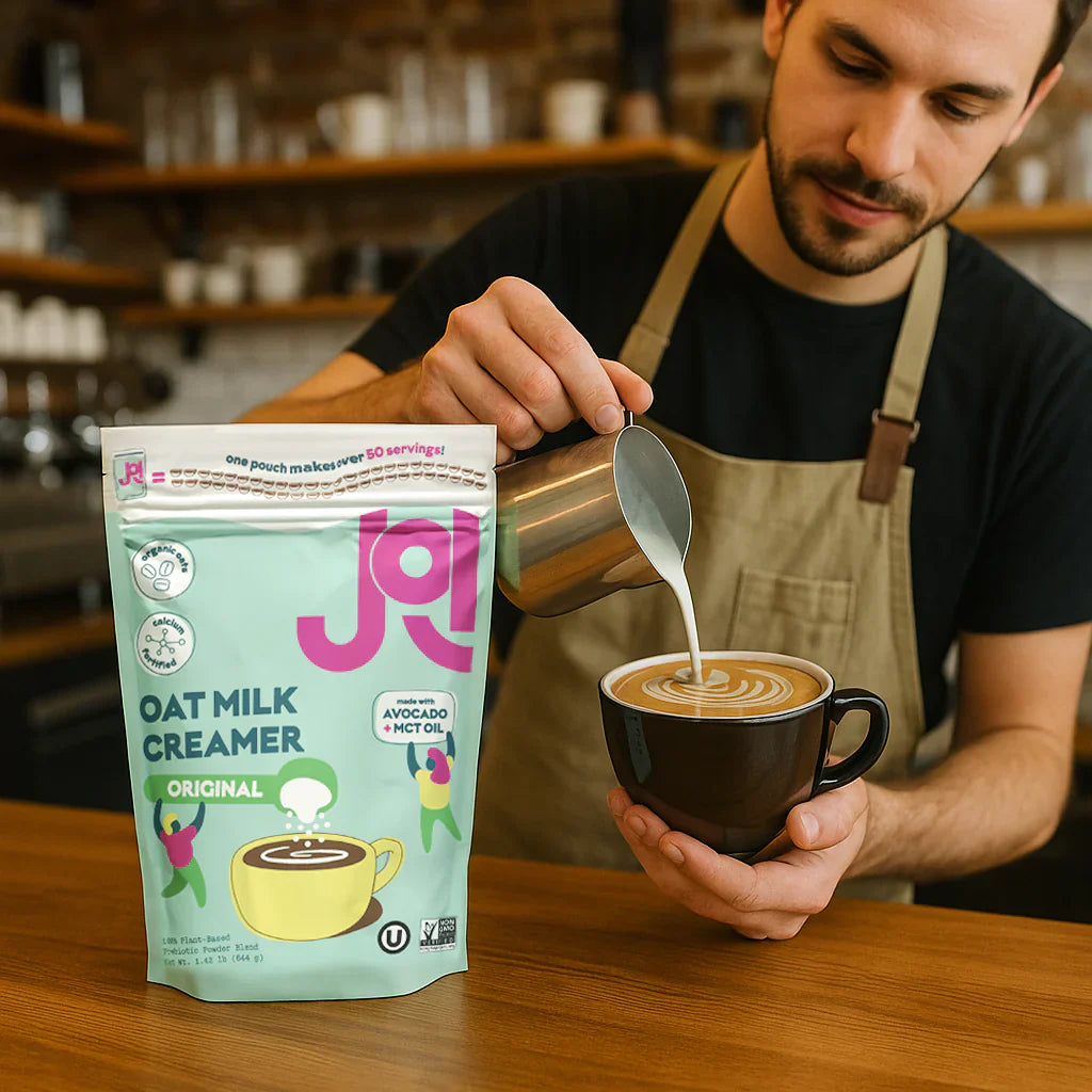 A person pours JOI Oat Milk Creamer Original into a cup of coffee.