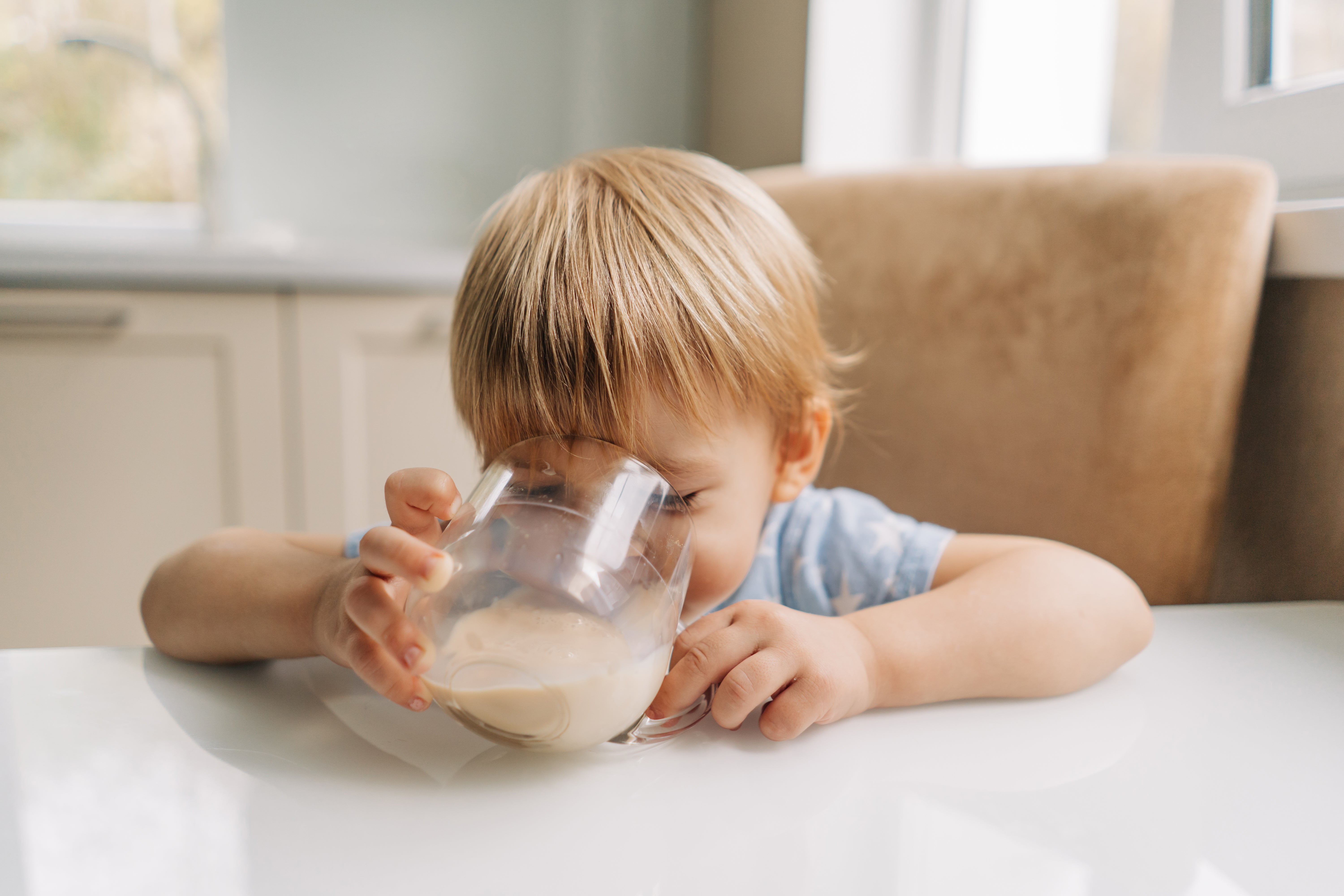 Child drinking plant-based milk from a glass, highlighting nutritious dairy-free options for growing kids.