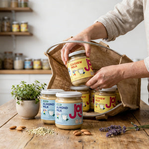 Almond and cashew milk concentrates being packed into a reusable shopping bag.