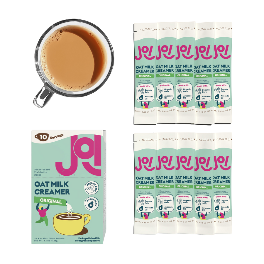 JOI oat milk creamer box and individual sachets arranged beside a cup of creamy coffee on a transparent background.