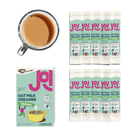 JOI oat milk creamer box and individual sachets arranged beside a cup of creamy coffee on a transparent background.
