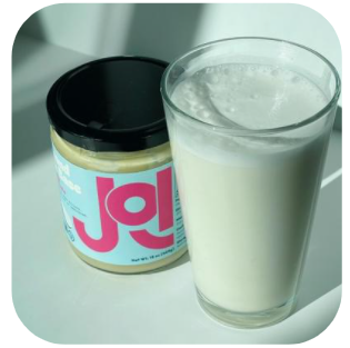 Photo of JOI Almond Base Glass Jar next to Cup of Fresh Almond Milk