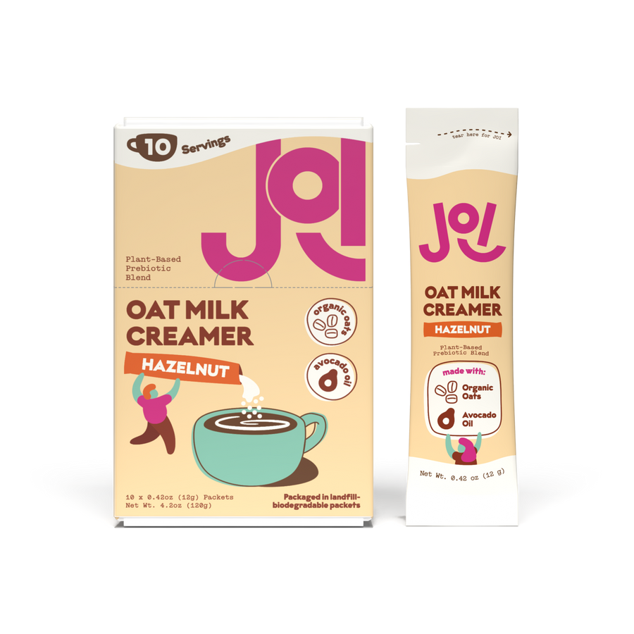 JOI Hazelnut Oat Milk Creamer box with matching single-serve stick pack beside it, featuring organic oats, avocado oil, and plant-based oat milk creamer branding.